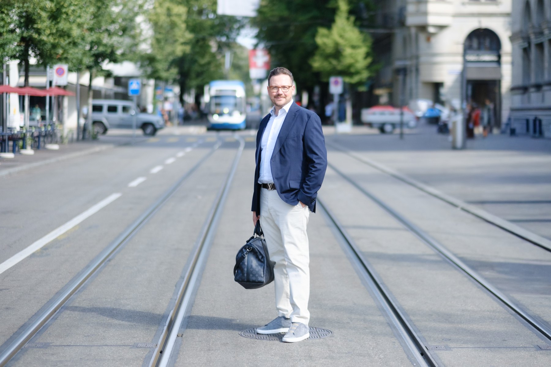 Oliver Gabor mit Reisetasche auf dem Weg zum Offsite, zwischen Tramgleisen in Zürich